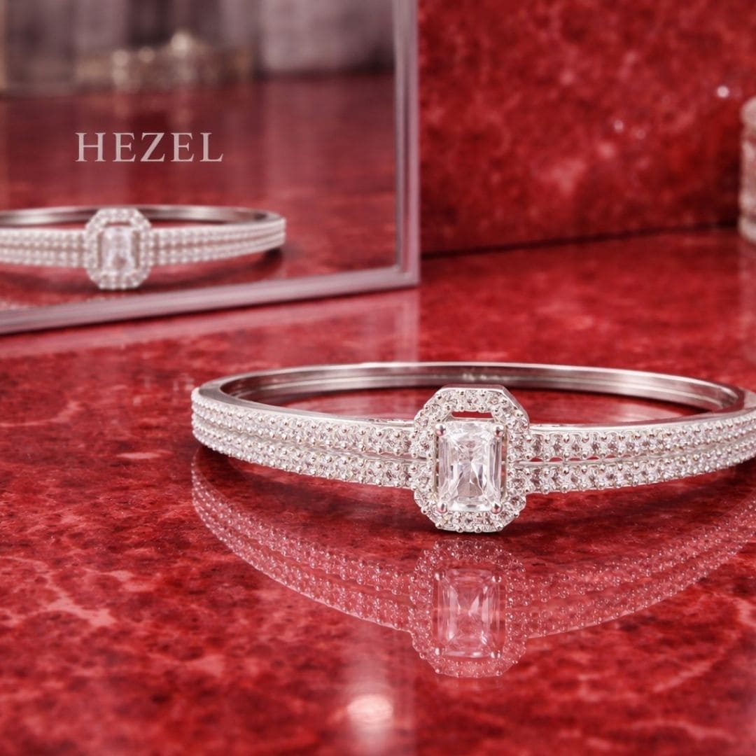 Premium silver crystal bracelet with elegant diamond detailing displayed on glossy red reflective surface for Hezel Jewellery.