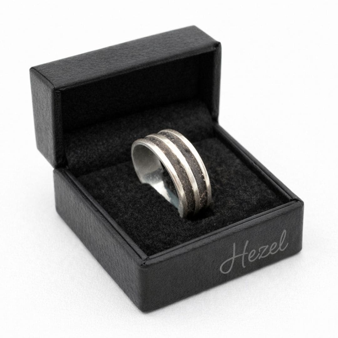 HEZEL silver band ring with textured center stripe displayed in black leather jewelry box on clean white background