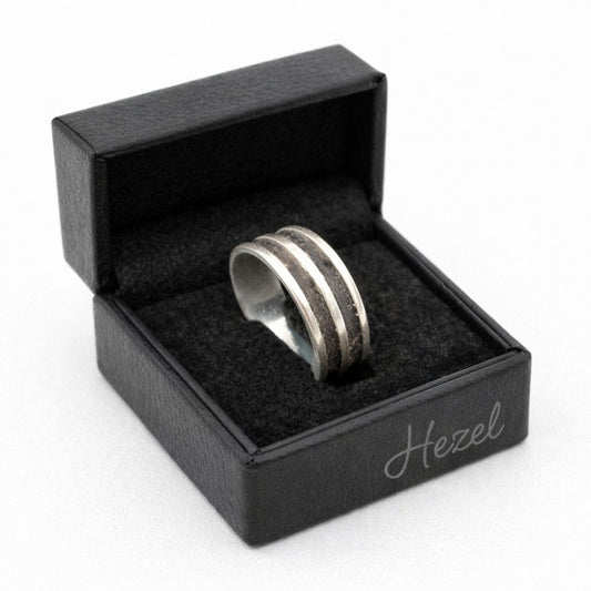 HEZEL silver band ring with textured center stripe displayed in black leather jewelry box on clean white background