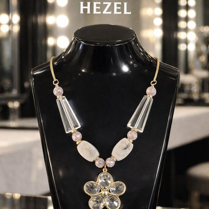 HEZEL crystal statement necklace with geometric beads and floral pendant, displayed on a premium black mannequin